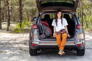 Woman hiker, hiking backpacker traveler camper looking at camera and relaxing photo