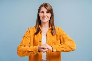 Smiling, happy, beautiful woman showing connection gesture, looking at camera photo