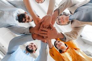 Diverse group of business people joining hands in circle selective focus photo