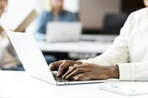 Programmer working on laptop developing software in coworking space photo