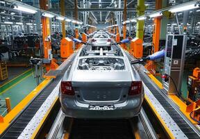 Advanced automotive assembly line featuring partially assembled cars moving on conveyor belts with robotic machinery photo