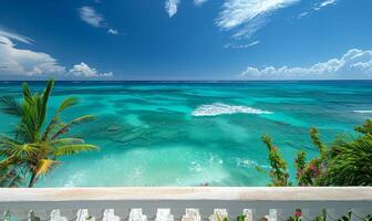 A crystal-clear turquoise ocean with gentle waves, seen from a balcony of a tropical resort photo