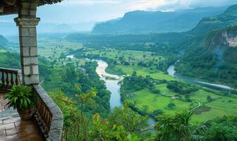 A panoramic view of a winding river through a lush valley, seen from a balcony of a highland retreat photo
