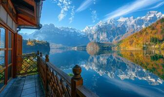 A picturesque alpine lake with reflection of surrounding mountains, seen from a balcony of a lakeside chalet photo