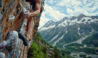 A rock climber's hands gripping a cliff edge, with mountains in the background photo