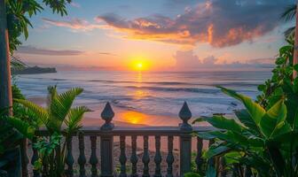 A sunrise over a tranquil beach, viewed from a balcony adorned with lush green plants photo