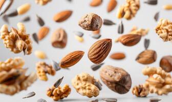 An array of nuts and seeds such as almonds, walnuts, and sunflower seeds flying in mid-air with a white background photo