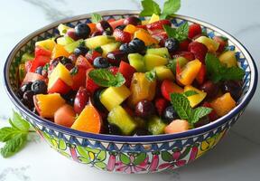 A colorful bowl of mixed fruit salad with exotic fruits and mint leaves photo