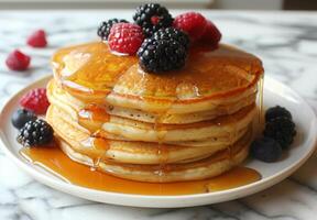 A stack of fluffy pancakes drizzled with maple syrup and topped with fresh berries photo