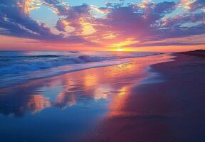 A tranquil beach at sunset, with vibrant colors reflecting off the water and sand photo