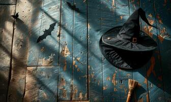 A witch's hat and broomstick lying on a wooden floor with shadows of bats, with plenty of space above for a message photo