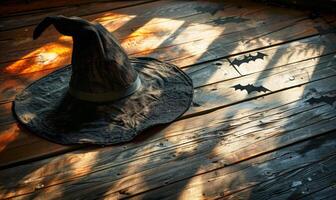 A witch's hat and broomstick lying on a wooden floor with shadows of bats, with plenty of space above for a message photo