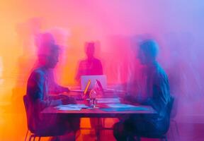 Fuzzy figures of coworkers discussing a project at a high table with laptops and papers photo