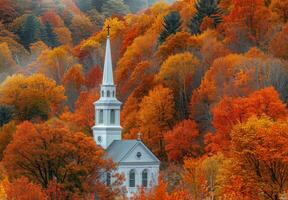A charming white church steeple rising above a sea of autumn trees photo