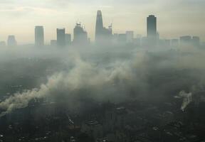 A city skyline shrouded in thick smog, with buildings barely visible through the haze photo
