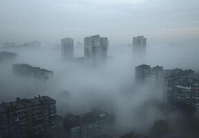 A city skyline shrouded in thick smog, with buildings barely visible through the haze photo