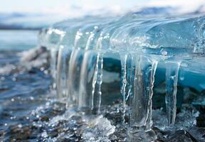 A close up of a melting glacier with clear water dripping down its surface photo