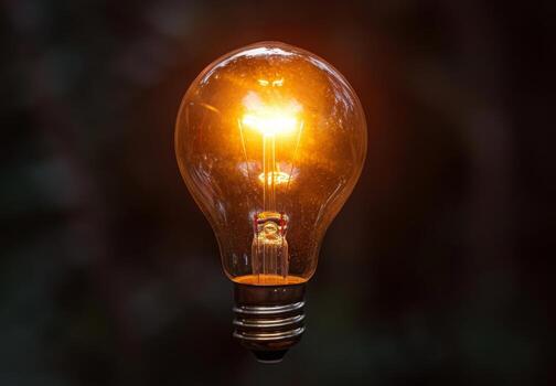 A light bulb is glowing in the dark photo