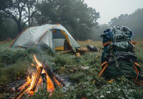 A tent and backpack are set up in a field photo