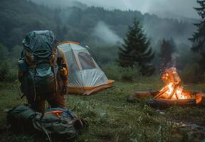 A person with a backpack and a tent near a campfire photo