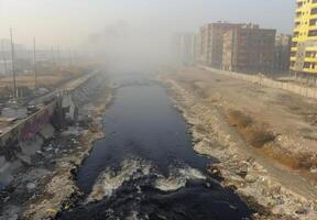 A river in a city with garbage and buildings photo