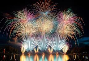 A spectacular finale of fireworks, with layers of colors and light filling the sky over a lake photo
