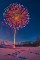 A vibrant fireworks display over a snowy landscape, creating contrast with the cold, dark surroundings photo