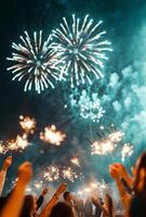 Fireworks illuminating a festive scene, with people holding sparklers in the foreground, celebrating the New Year photo