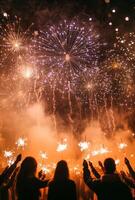 Fireworks illuminating a festive scene, with people holding sparklers in the foreground, celebrating the New Year photo