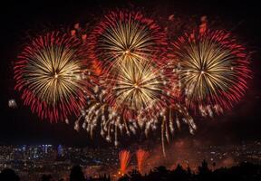 Golden and red fireworks spreading across the sky, with city lights twinkling in the background photo