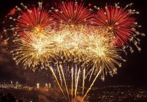 Golden and red fireworks spreading across the sky, with city lights twinkling in the background photo