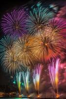 Multiple fireworks of different colors going off simultaneously, lighting up the night with vivid patterns photo