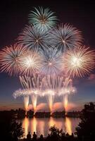 A spectacular finale of fireworks, with layers of colors and light filling the sky over a lake photo