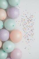 Muted pastel-colored balloons positioned on the left side, with scattered confetti, and an open space on the right for a message or design photo