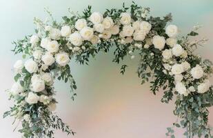 A white archway with white roses and eucalyptus photo
