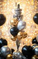 A luxurious birthday setting with black, gold, and silver balloons, a champagne tower, and sparkling lights for an elegant celebration photo