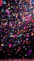 A vibrant scene of confetti fluttering through the air, with bold, colorful streaks of light illuminating the falling pieces against a deep black background photo