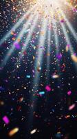 Bright, colorful confetti falling against a dark background, illuminated by sharp rays of light cutting through the scene, creating a festive and dynamic atmosphere photo