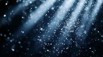 Dynamic image of swirling confetti, caught in beams of white light, with the dark background enhancing the brightness and movement of the scene photo