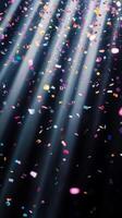 Soft, multicolored confetti drifting through shafts of light, with the dark background creating a stark, captivating contrast photo