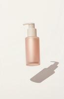 A sleek, plain cosmetic pump bottle floating horizontally in mid-air, casting a delicate shadow on a white background photo