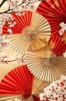 Red and gold oriental paper fans with cherry blossoms photo