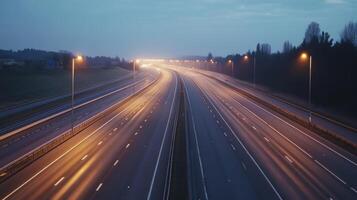 A quiet highway at dusk, illuminated by streetlights, with a soft glow on the asphalt photo