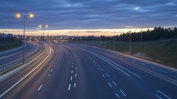 A quiet highway at dusk, illuminated by streetlights, with a soft glow on the asphalt photo