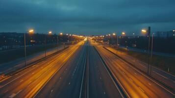 A quiet highway at dusk, illuminated by streetlights, with a soft glow on the asphalt photo