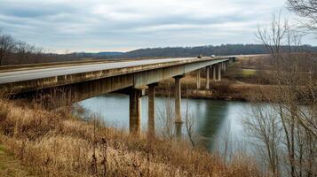 An expansive highway bridge crossing over a river, surrounded by nature and no signs of human activity photo