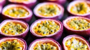 Rows of halved passion fruit, the bright yellow seeds forming a striking repeating pattern against the purple skin photo
