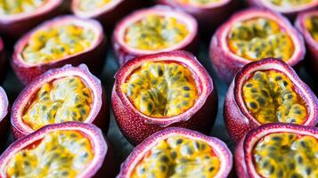 Rows of halved passion fruit, the bright yellow seeds forming a striking repeating pattern against the purple skin photo