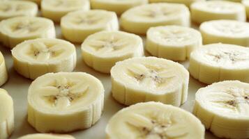 Closeup of arranged rows of banana slices, their creamy color creating a soft repeating texture photo