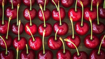 Top-down view of rows of red cherries with stems, filling the frame with a rich, vibrant color pattern photo